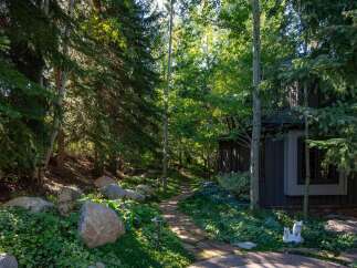 Discover a serene retreat with this stunning property, featuring a beautifully landscaped pathway leading to a charming home.