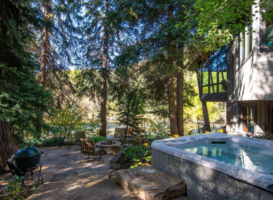 Escape to your own private oasis with this stunning property! Enjoy the tranquility of nature with a hot tub, outdoor seating, and a cozy fire pit.