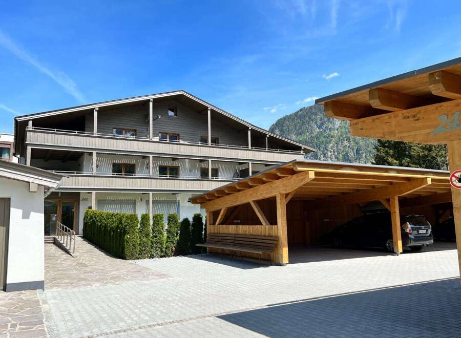Discover a charming property featuring a stylish wooden carport, perfect for protecting your vehicles.
