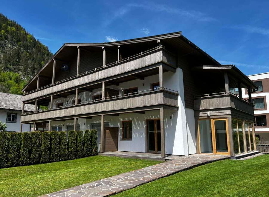 Discover the charm of this stunning property, featuring a beautifully designed exterior with wooden accents and multiple balconies.