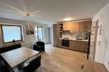 This modern apartment boasts a stylish kitchen with wooden cabinetry and sleek countertops.