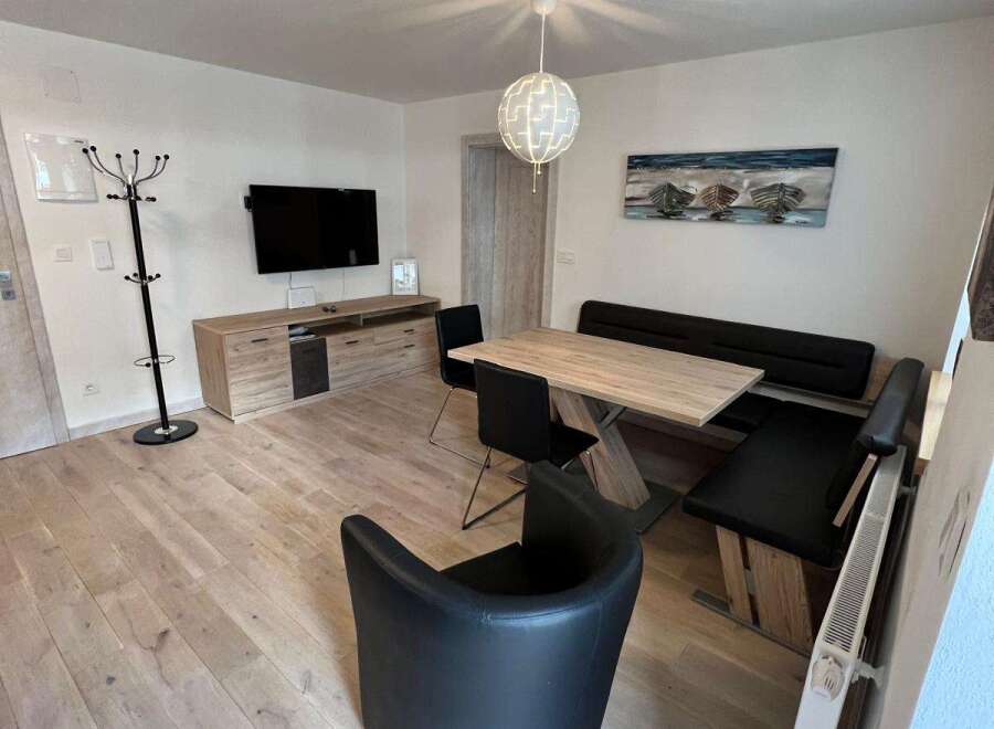 This modern living space features a stylish dining area with a sleek table and comfortable seating.