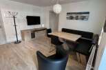 This modern living space features a stylish dining area with a sleek table and comfortable seating.
