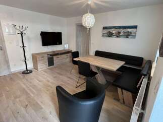 This modern living space features a stylish dining area with a sleek table and comfortable seating.