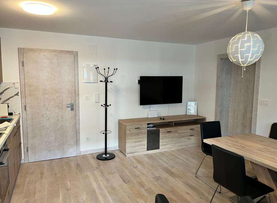 This modern living space features a sleek entertainment unit with a mounted TV, perfect for cozy nights in.