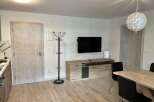 This modern living space features a sleek entertainment unit with a mounted TV, perfect for cozy nights in.