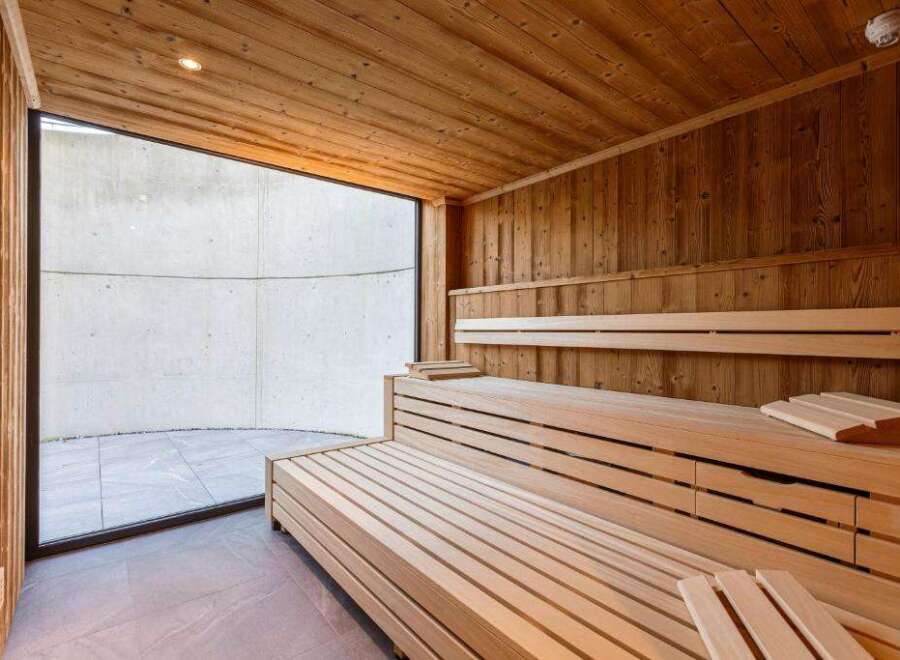 Step into relaxation with this stunning sauna, featuring warm wooden interiors and a spacious design.