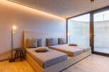 Experience ultimate relaxation in this luxurious bedroom featuring two comfortable beds and a stylish design.