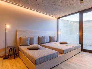 Experience ultimate relaxation in this luxurious bedroom featuring two comfortable beds and a stylish design.