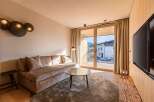 Experience modern living in this stylish property, featuring a cozy living room with a comfortable sofa and a unique wall-mounted light fixture.