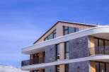 This stunning modern property boasts a unique architectural design, featuring a combination of wood and stone elements.