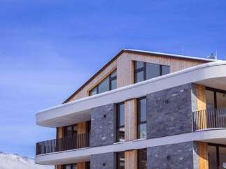 This stunning modern property boasts a unique architectural design, featuring a combination of wood and stone elements.