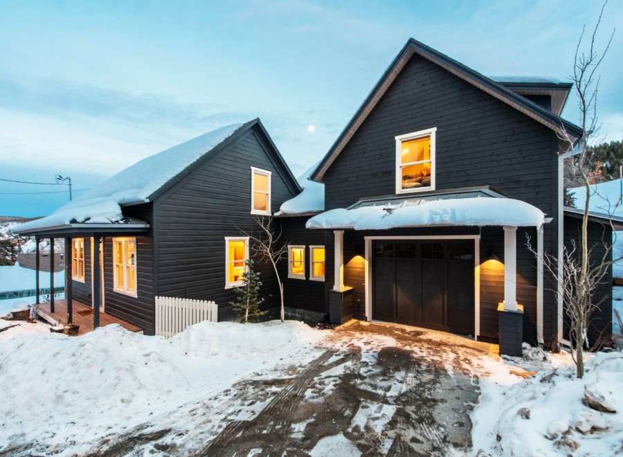 This stunning mountain home boasts two charming dark-wood buildings, perfect for a cozy retreat.