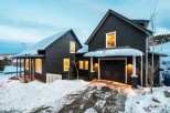 This stunning mountain home boasts two charming dark-wood buildings, perfect for a cozy retreat.