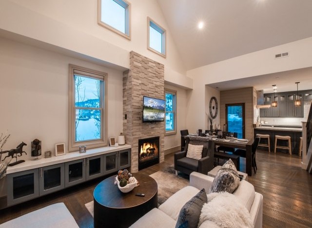 This stunning vacation rental boasts an open-concept living area with a cozy fireplace, perfect for relaxing after a day of adventure.