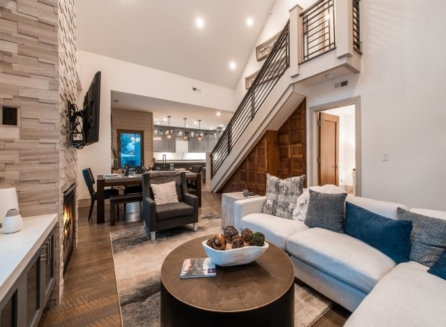 Stunning mountain home with open-concept living, featuring a cozy fireplace and expansive windows.