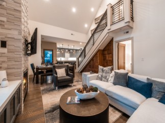 Stunning mountain home with open-concept living, featuring a cozy fireplace and expansive windows.
