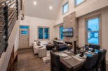 This stunning property boasts an open-concept living area with vaulted ceilings and large windows offering breathtaking views.