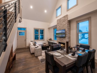 This stunning property boasts an open-concept living area with vaulted ceilings and large windows offering breathtaking views.