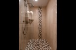 This luxurious bathroom boasts a spacious shower with elegant fixtures and a stunning mosaic tile design.