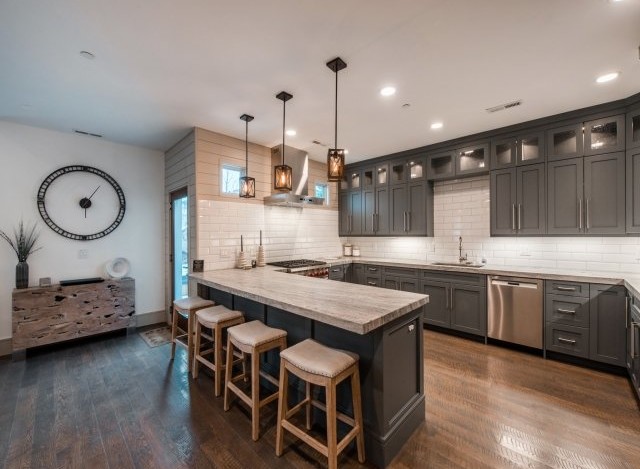 Stunning kitchen with gray cabinetry, quartz countertops, and hardwood floors.