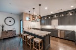 Stunning kitchen with gray cabinetry, quartz countertops, and hardwood floors.