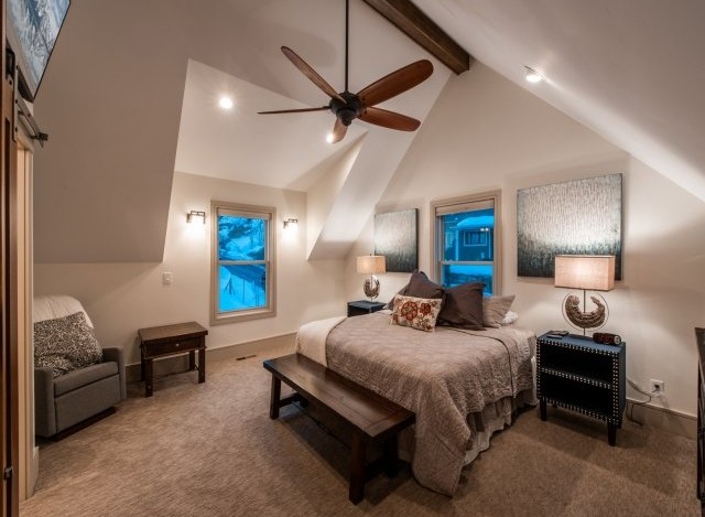 Relax in this cozy bedroom featuring a king-size bed, vaulted ceilings, and stunning mountain views.