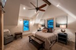 Relax in this cozy bedroom featuring a king-size bed, vaulted ceilings, and stunning mountain views.