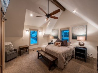 Relax in this cozy bedroom featuring a king-size bed, vaulted ceilings, and stunning mountain views.