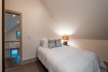 Cozy attic bedroom with a queen-size bed, offering a tranquil retreat.