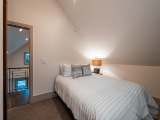 Cozy attic bedroom with a queen-size bed, offering a tranquil retreat.