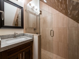 This luxurious bathroom boasts a spacious shower with glass enclosure and elegant tile work.