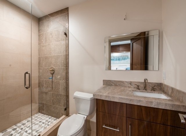 This stunning bathroom boasts a spacious shower with glass enclosure and geometric tile floor.