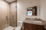 This stunning bathroom boasts a spacious shower with glass enclosure and geometric tile floor.