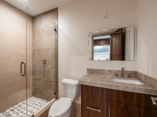 This stunning bathroom boasts a spacious shower with glass enclosure and geometric tile floor.