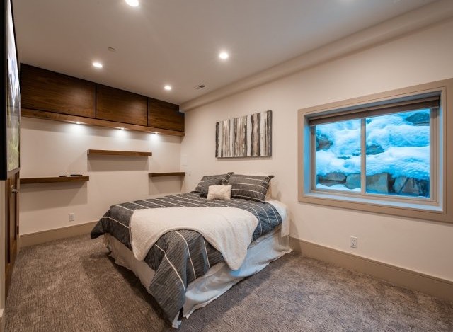 Cozy basement bedroom with a stunning view of a snow-covered landscape outside the window.