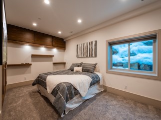 Cozy basement bedroom with a stunning view of a snow-covered landscape outside the window.