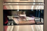 This stunning kitchen features a built-in Wolf double oven, boasting a sleek stainless steel finish and modern design.