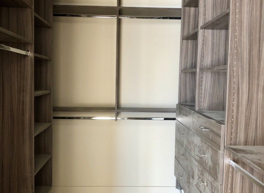 This stunning walk-in closet boasts ample shelving and hanging space, perfect for organizing your wardrobe.