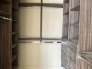 This stunning walk-in closet boasts ample shelving and hanging space, perfect for organizing your wardrobe.
