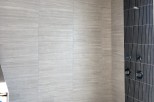 This stunning bathroom boasts a luxurious shower with a unique combination of light gray and dark gray tiles.