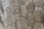 Stunning hexagon wood-look tiles create a unique and modern wall design.