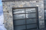 This stunning property boasts a modern stone exterior with a sleek, contemporary garage door.