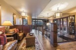 This luxurious lodge boasts a stunning hallway with hardwood floors, leather seating areas, and large windows offering breathtaking mountain views.