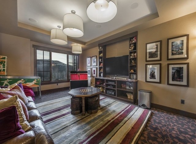 This luxurious family room boasts a large window showcasing stunning mountain views, creating a bright and inviting atmosphere.