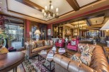 Luxurious lodge with a grand lobby featuring comfortable leather sofas, a beautiful oriental rug, and a stunning stone fireplace.