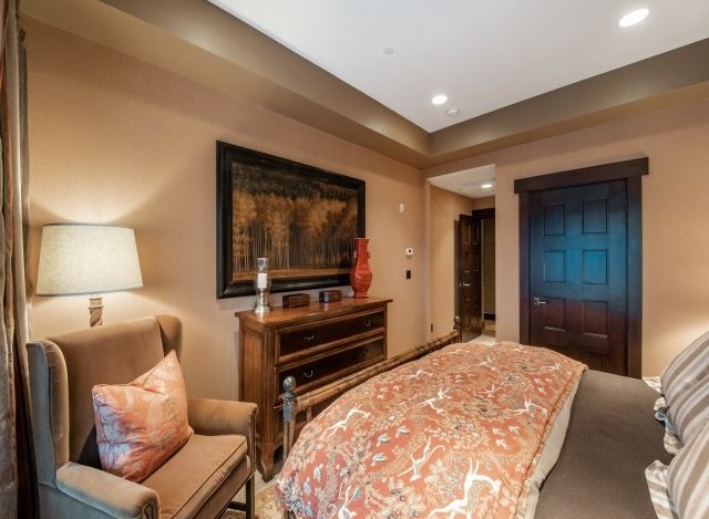 Luxurious bedroom with a king-size bed, featuring an elegant comforter and plush pillows.