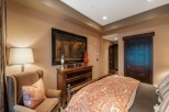 Luxurious bedroom with a king-size bed, featuring an elegant comforter and plush pillows.