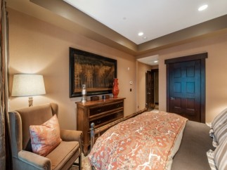 Luxurious bedroom with a king-size bed, featuring an elegant comforter and plush pillows.