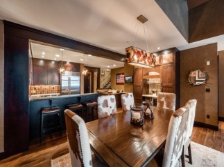 This stunning property boasts a spacious dining area with a rustic-chic design, featuring a large wooden table and cowhide chairs.